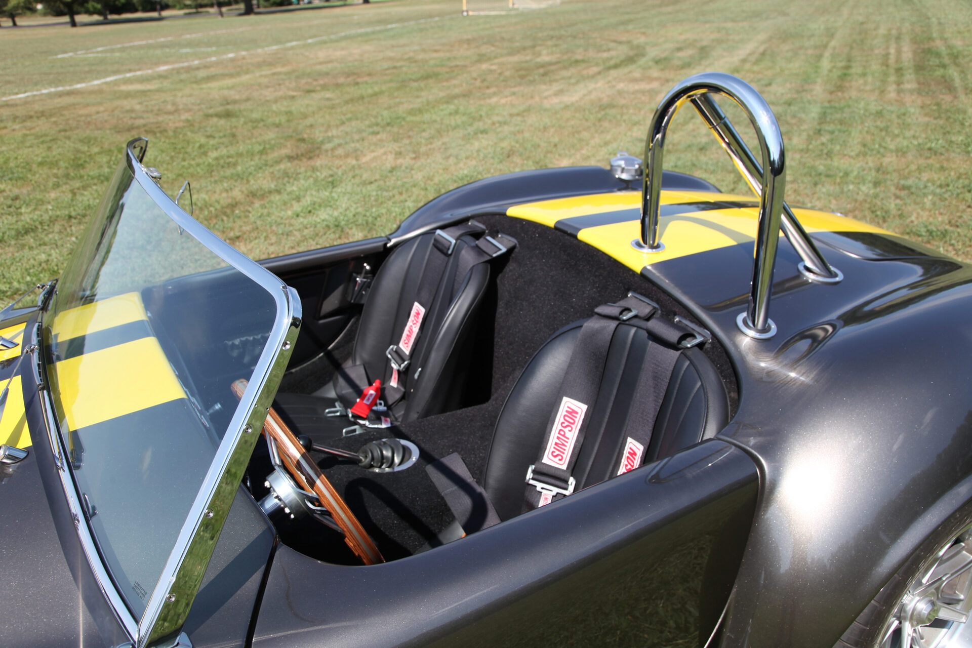 Cockpit view showing both bucket seats with Simpson racing harnesses